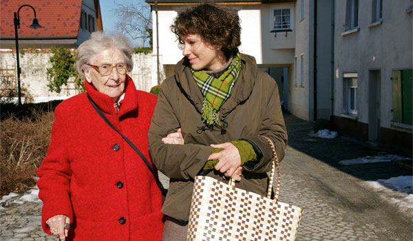 Alltagsbetreuerin unterstützt Senioren beim Gang zum Markt.