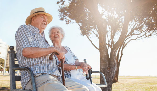 Ein Seniorenpaar sitzen während ihres Urlaubs auf einer Bank.