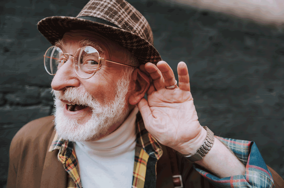 Ein älterer Mann versucht zu hören. Dabei legt er seine Hand ans Ohr.