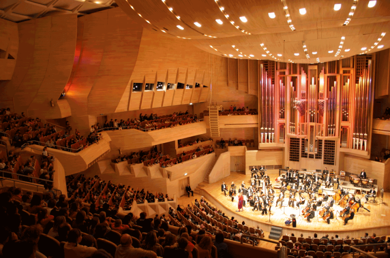 Ein Konzertsaal in dem Menschen einem klassischen Konzert lauschen.