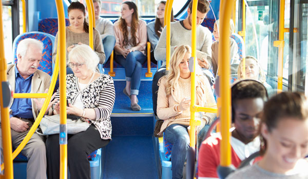 Viele Menschen sitzen in einem öffentlichen Bus.