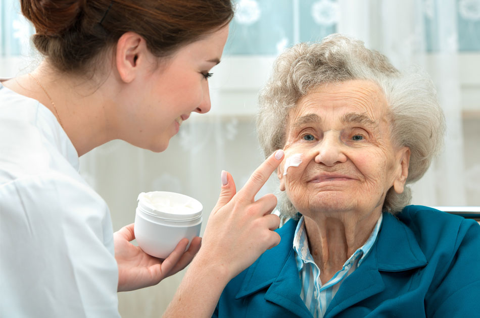 Eine Osteuropäische Pflegekraft kümmert sich um eine Seniorin.