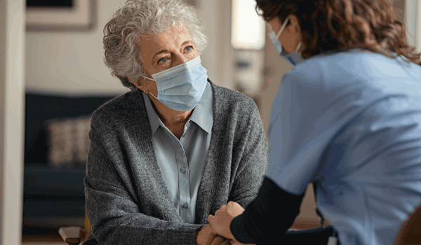 Eine Pflegerin kümmert sich um eine Seniorin.
