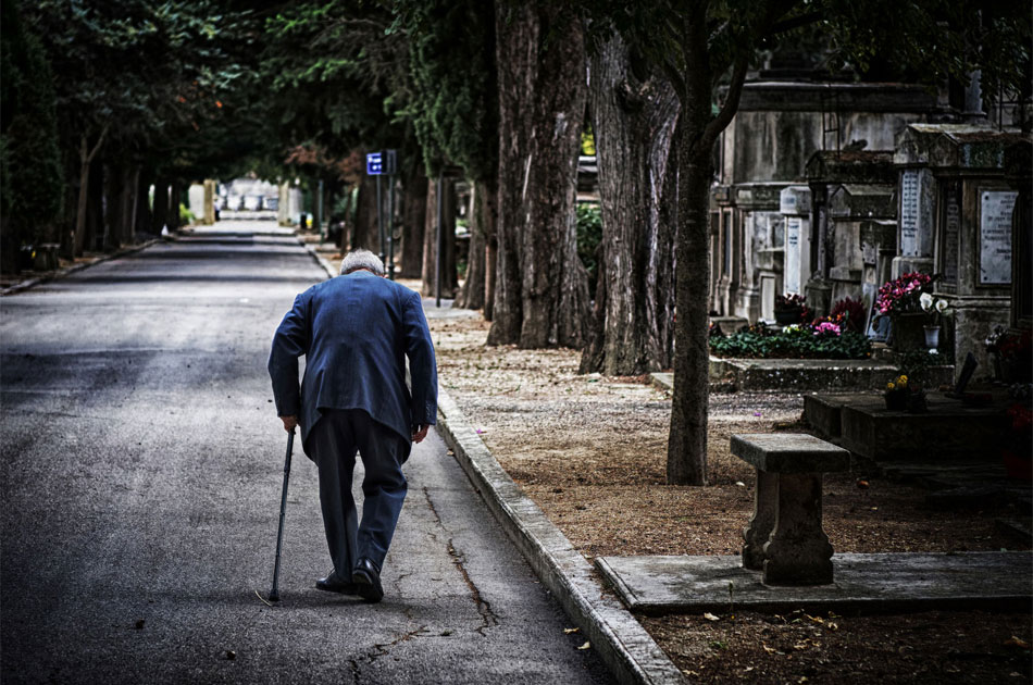 Ein Mann einsam und allein unterwegs auf einem Friedhof