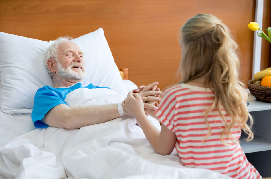Opa wird im Krankenhaus von seiner Enkelin besucht.