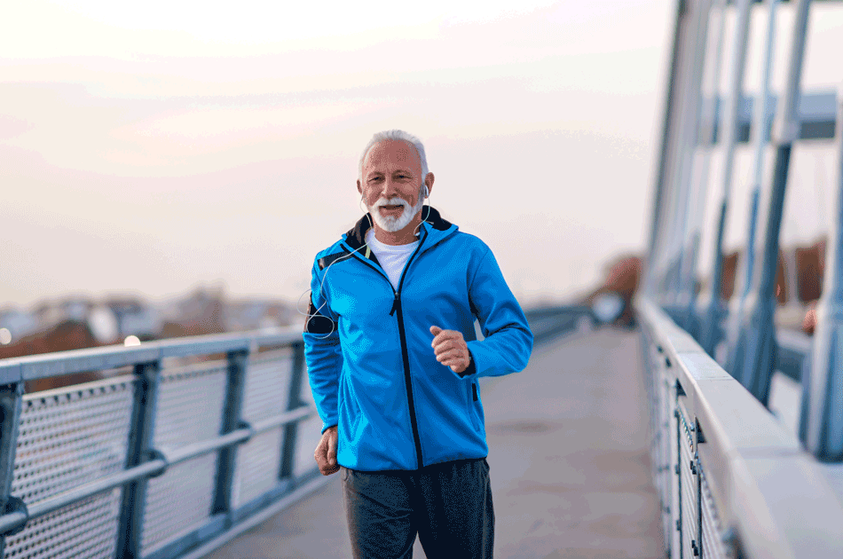Ein älterer Mann joggt über eine Brücke.