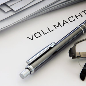 Eine Generalvollmacht liegt auf einem Schreibtisch dazu ein Stift und eine Brille.