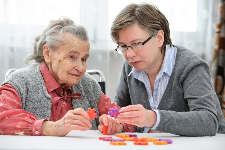 Beschäftigungen für Demenzkranke: Eine Frau Demenz macht mir ihrer Betreuerin ein Puzzle.