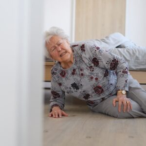 Eine Seniorin liegt nach einem Sturz auf dem Boden.