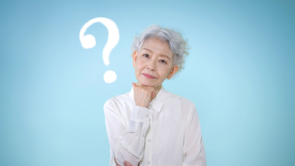 Portrait einer Seniorin mit Fragezeichen im Hintergrund.
